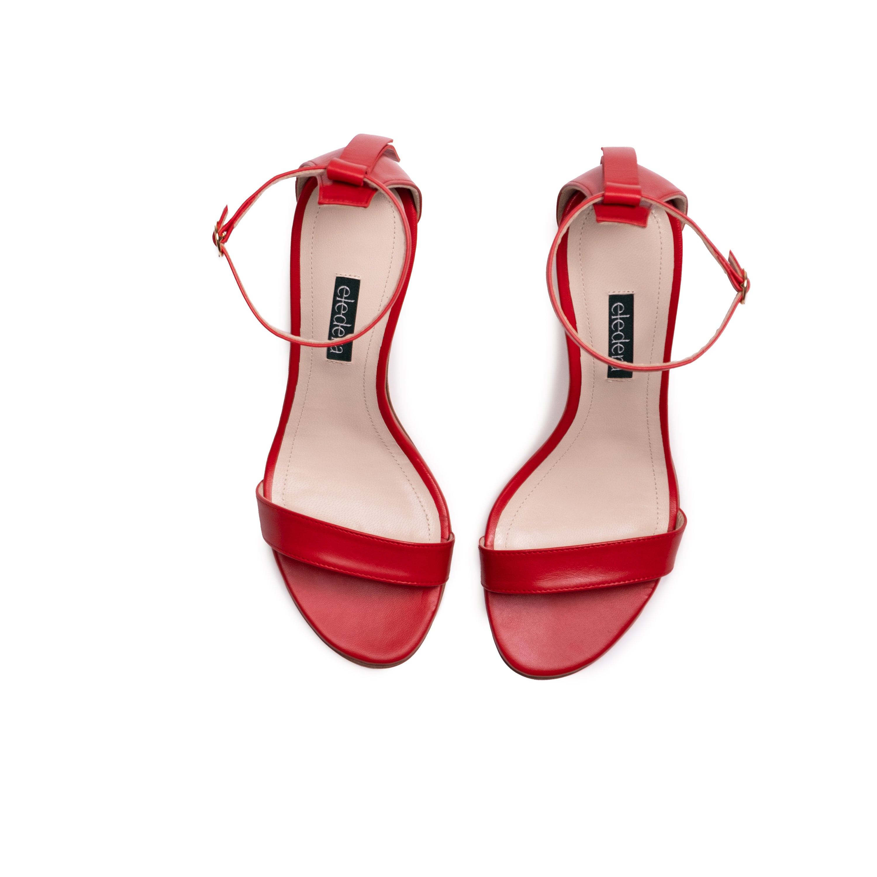 The Eledera Tacco in red nappa leather, 7cm heel, adjustable strap with golden buckle and embellished tassel on the back.