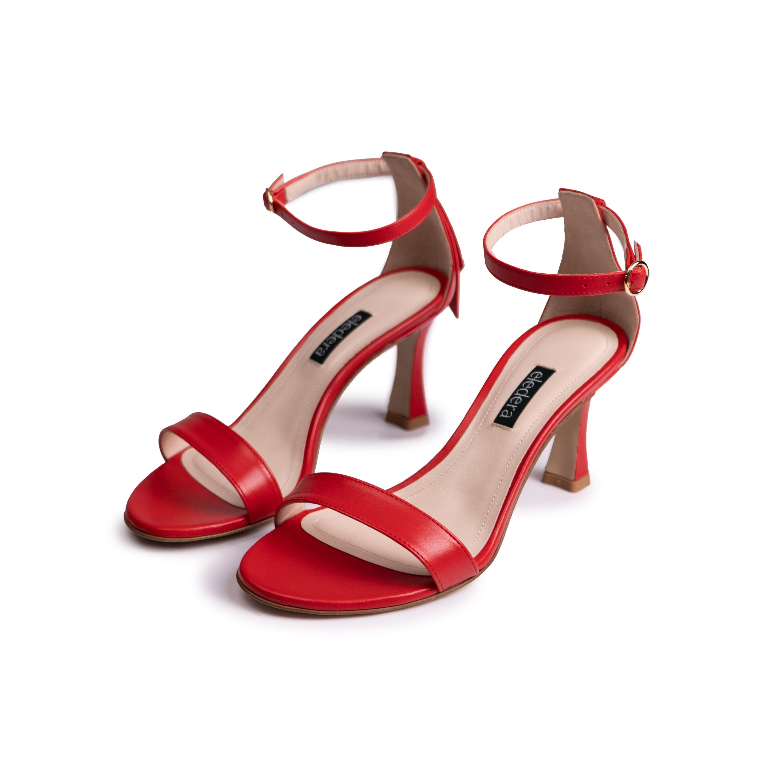 The Eledera Tacco in red nappa leather, 7cm heel, adjustable strap with golden buckle and embellished tassel on the back.