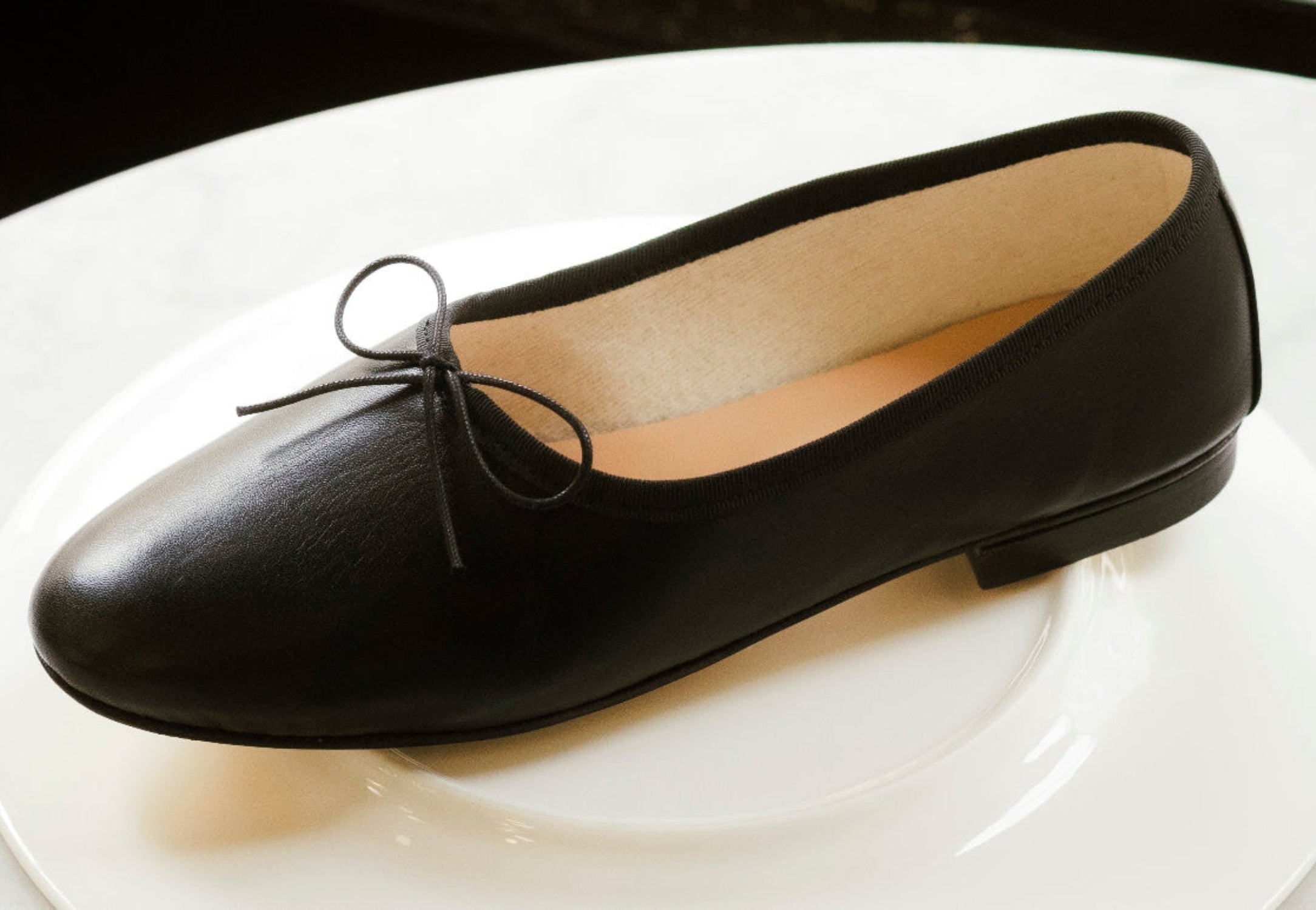 Black flat shoe with a bow on a white background