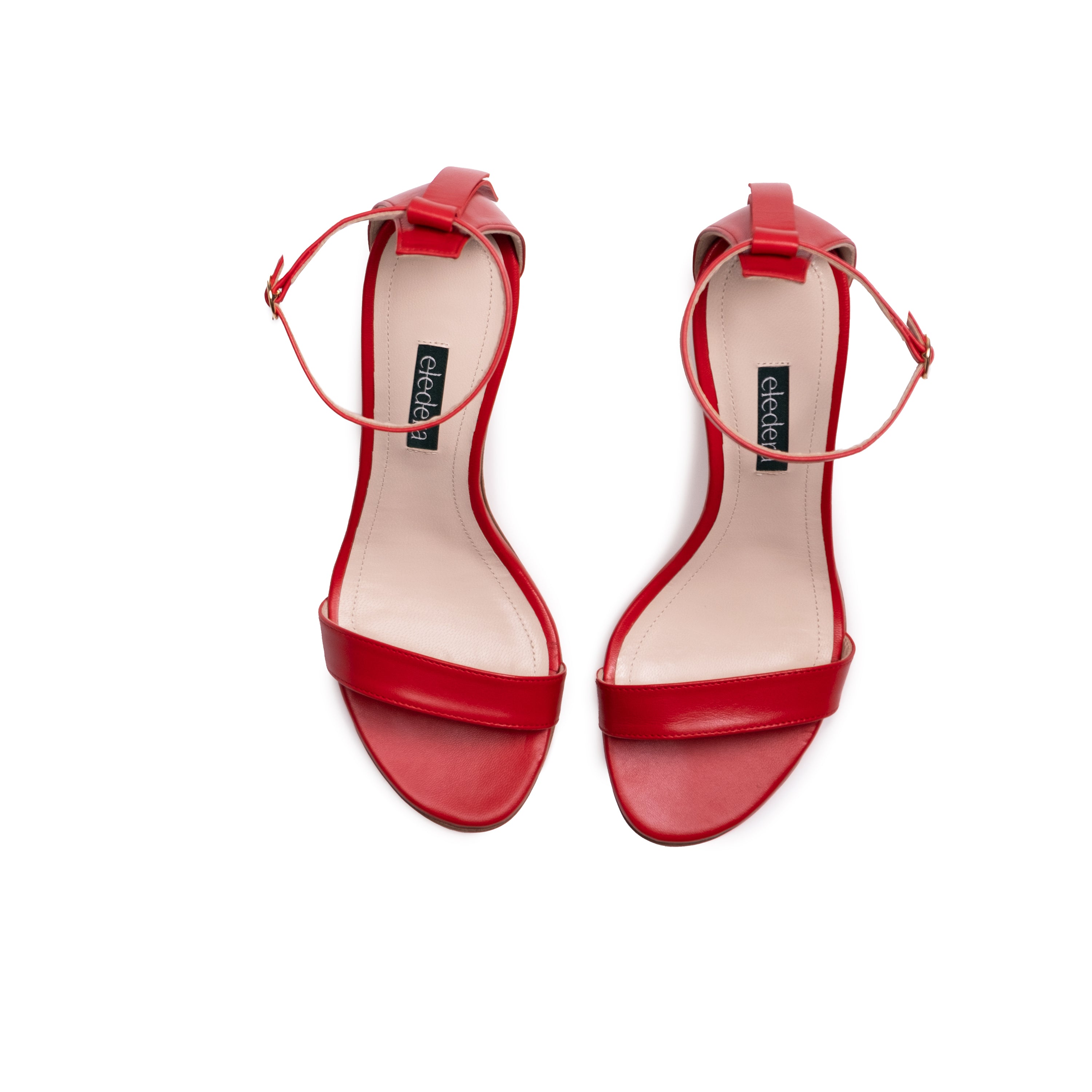The Eledera Tacco in red nappa leather, 7cm heel, adjustable strap with golden buckle and embellished tassel on the back. 